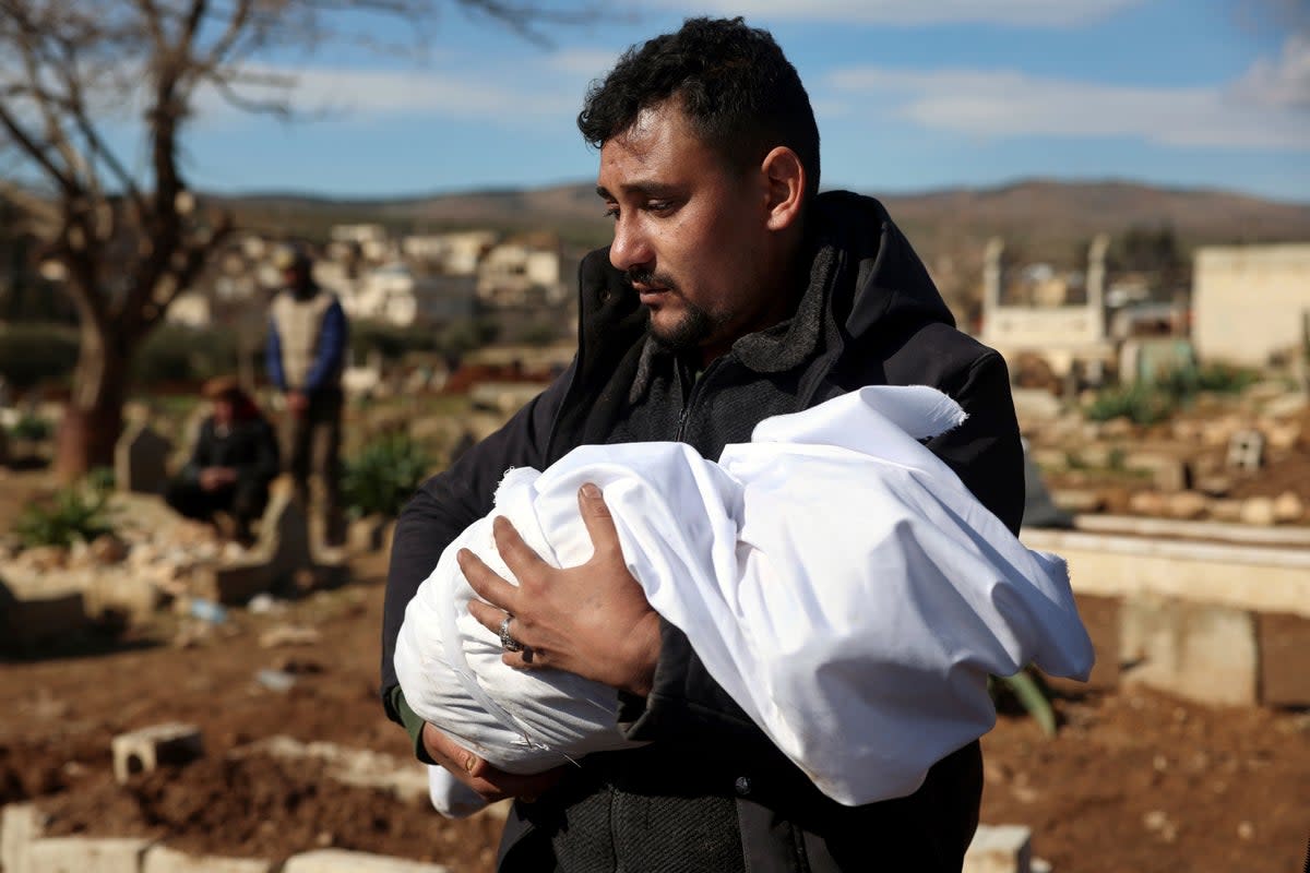 A man carries the body of a family member who died in a devastating earthquake that rocked Syria and Turkey at a cemeter (Copyright 2023 The Associated Press. All rights reserved)