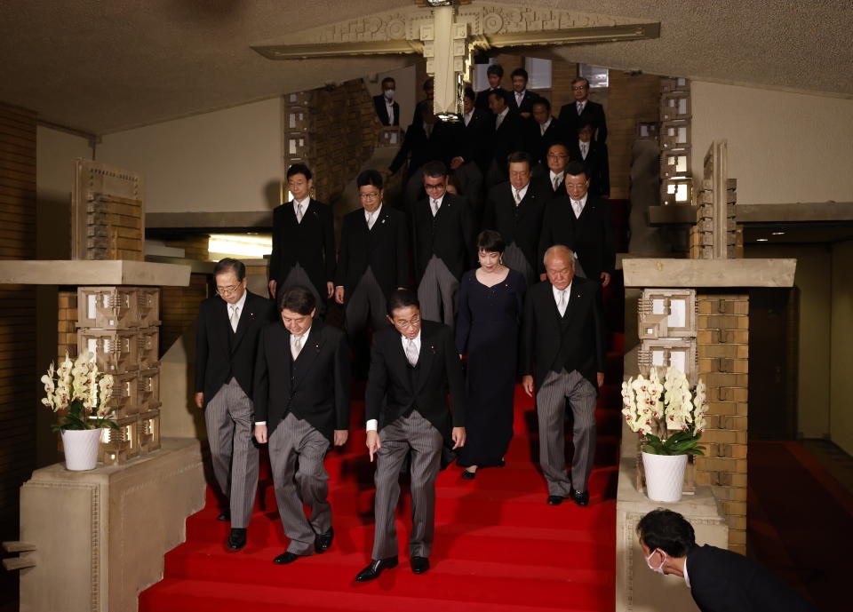 Japan's Prime Minister Fumio Kishida, front center, leads his cabinet ministers as they prepare for a photo session at Kishida's residence Wednesday, Aug. 10, 2022, in Tokyo. (Issei Kato/Pool Photo via AP)