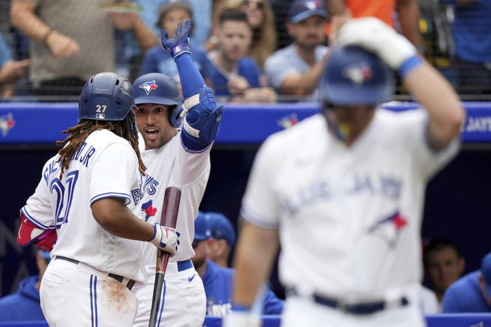 Toronto Blue Jays right fielder George Springer (4) celebrates his solo home run with teammate Vladimir Guerrero Jr. (27) during fourth inning of a baseball game against the Kansas City Royals, in Toronto, Saturday, Sept. 9, 2023. (Nathan Denette /The Canadian Press via AP)