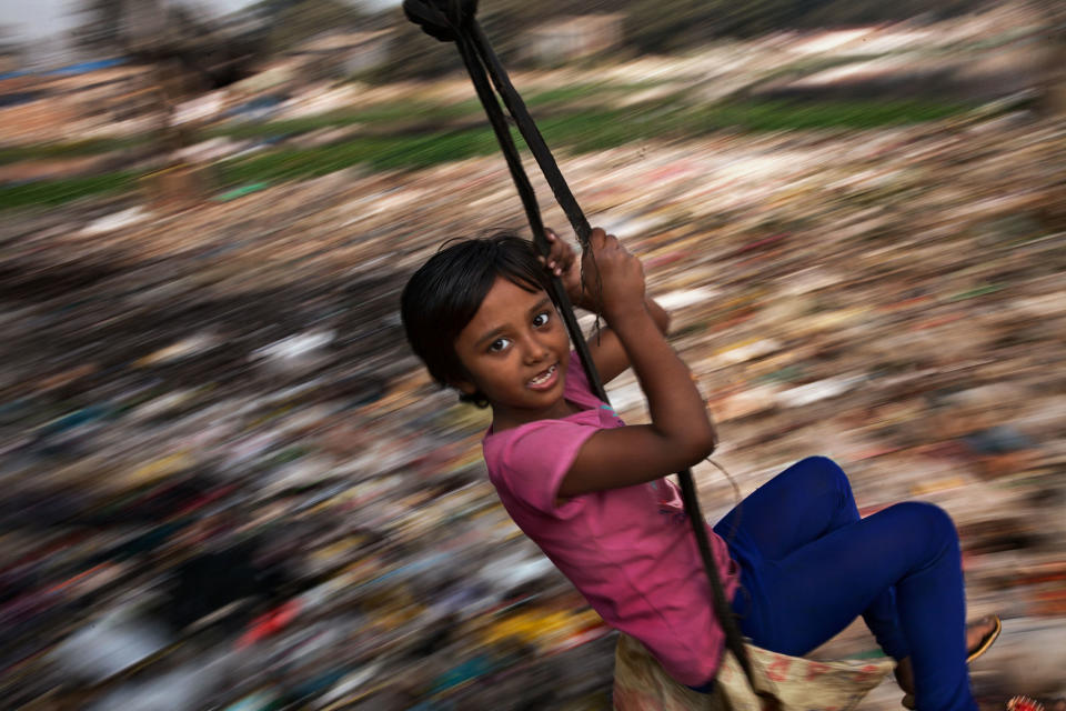 A Bangladeshi girl plays on a swing in Dhaka