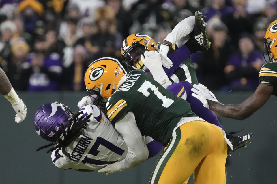 Minnesota Vikings wide receiver K.J. Osborn (17) is tackled by Green Bay Packers linebacker Quay Walker (7) after catching a pass during the first half of an NFL football game, Sunday, Jan. 1, 2023, in Green Bay, Wis. (AP Photo/Morry Gash)