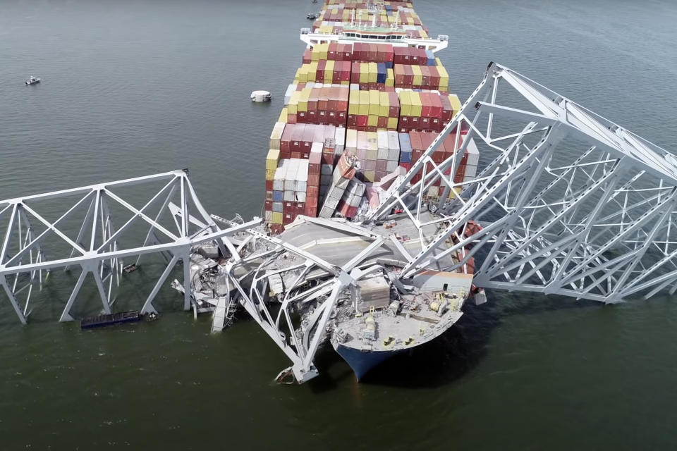 In this image taken from video released by the National Transportation and Safety Board, the cargo ship Dali is stuck under part of the structure of the Francis Scott Key Bridge after the ship hit the bridge, Tuesday, March 26, 2024, in Baltimore. (NTSB via AP)