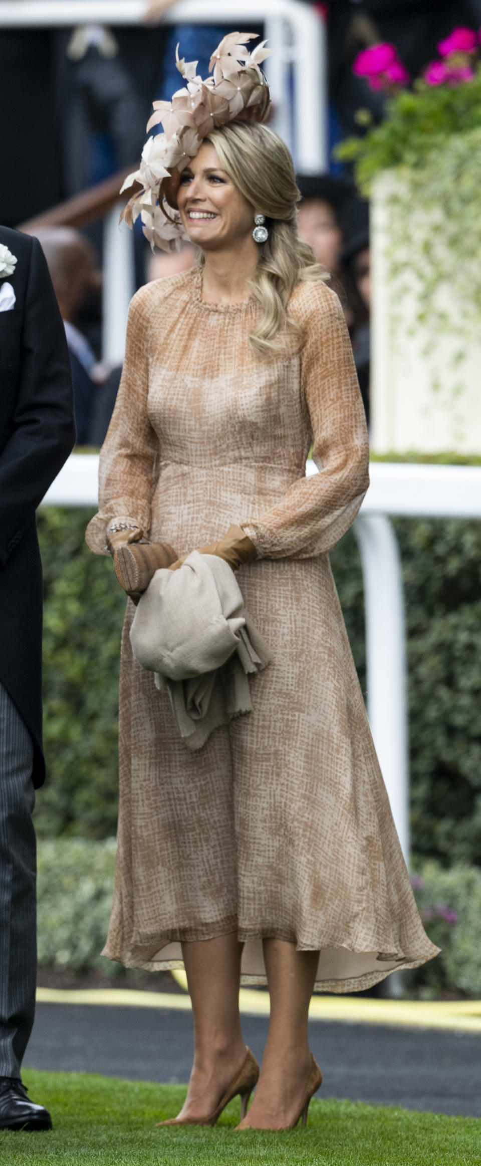 Queen Maxima of The Netherlands wore a nude-blush midi dress with semi-sheer cuffed sleeves and a floral hat, with earrings from the Stuart Tiara. <em>[Photo: Getty]</em>