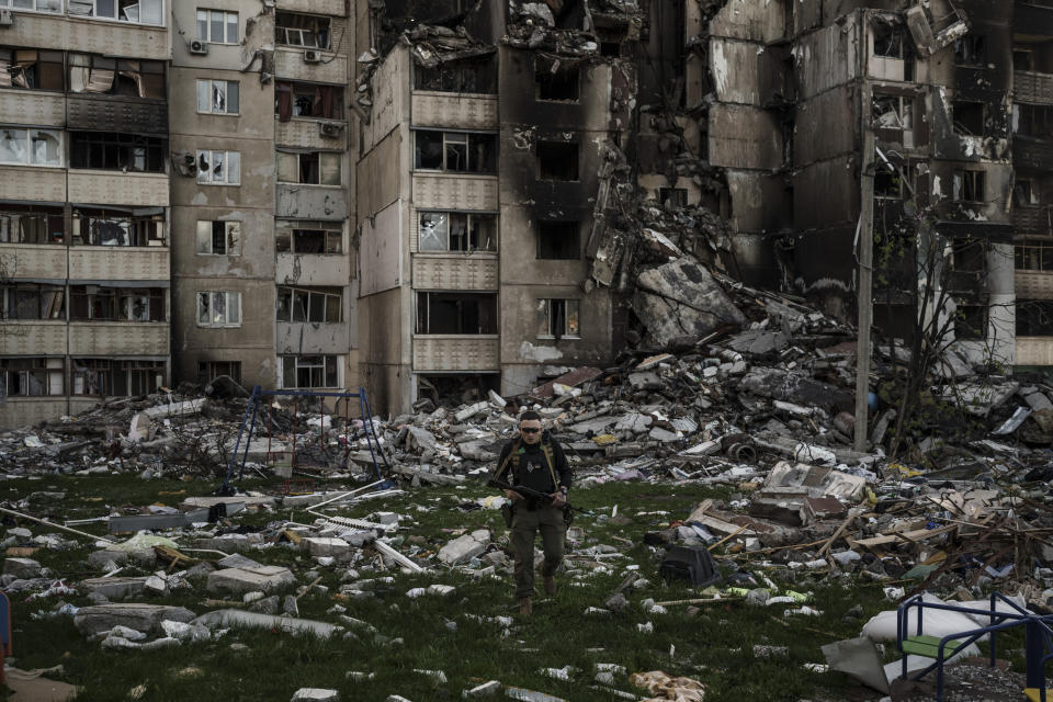 FILE - A Ukrainian serviceman walks amid the rubble of a building heavily damaged by multiple Russian bombardments near a frontline in Kharkiv, Ukraine, Monday, April 25, 2022. Russia's war on Ukraine will top the agenda when U.S. President Joe Biden and his NATO counterparts meet in the Lithuanian capital Vilnius on Tuesday and Wednesday. (AP Photo/Felipe Dana, File)