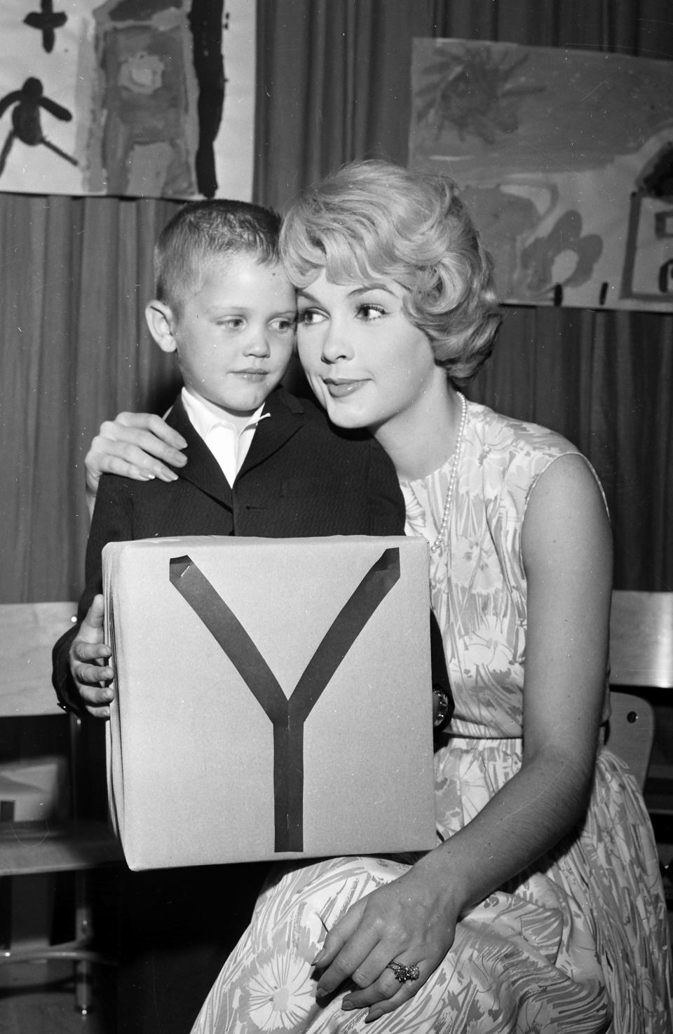 Tiny Andy - the future actor/director Andrew Stevens - gets a hug from his movie star mother, Stella Stevens, after his performance in a play at Holy Rosary School on May 30, 1961.