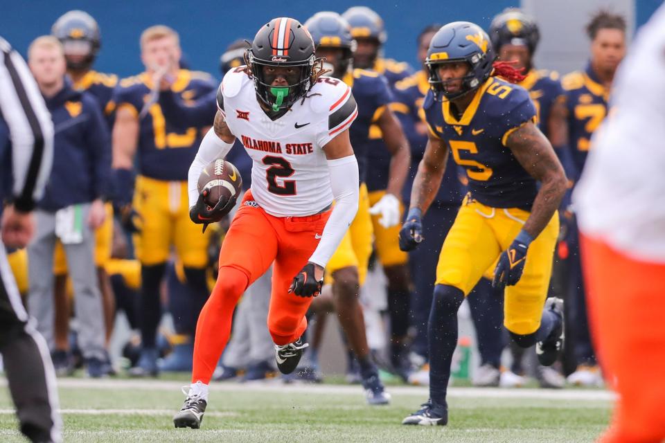 Oklahoma State cornerback Korie Black (2) runs with the ball and intercepting a pass against West Virginia on Saturday in Morgantown, W. Va.