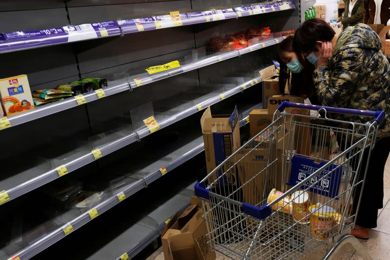 FILE PHOTO: Customers wear masks as they shop for instant noodles at a supermarket following the outbreak of a new coronavirus, in Hong Kong