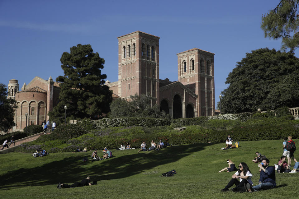 FILE - Students sit on the lawn near Royce Hall at UCLA in the Westwood section of Los Angeles on April 25, 2019. University of California, Los Angeles, officials have ordered all classes to be held remotely due to threats. UCLA took the step Tuesday, Feb. 1, 2022, a day after students returned to in-person instruction and university officials say the move was made out of an abundance of caution. (AP Photo/Jae C. Hong, File)