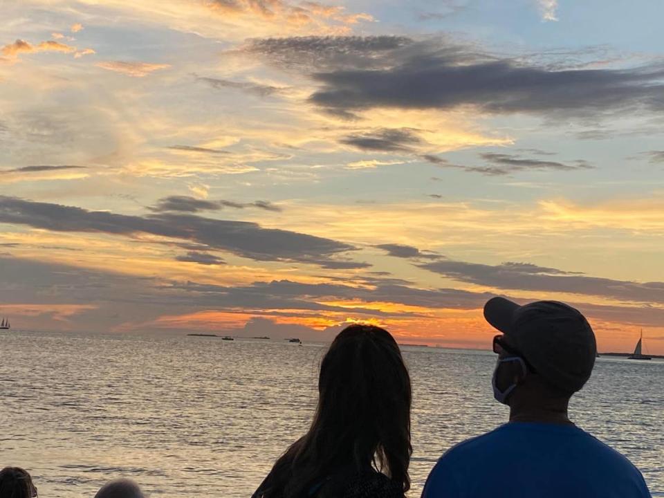 A couple watches the sunset from Mallory Square in Key West.