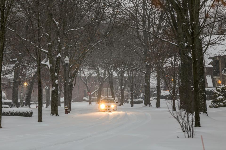 A lone car drives down unplowed street of snow early Saturday morning, Jan. 18, 2020.