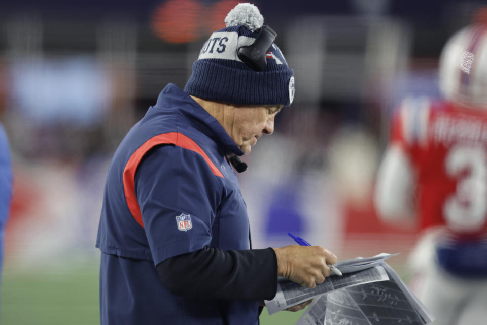New England Patriots head coach Bill Belichick reviews print outs of previous plays during the first half of an NFL football game against the Buffalo Bills, Thursday, Dec. 1, 2022, in Foxborough, Mass. (AP Photo/Michael Dwyer)