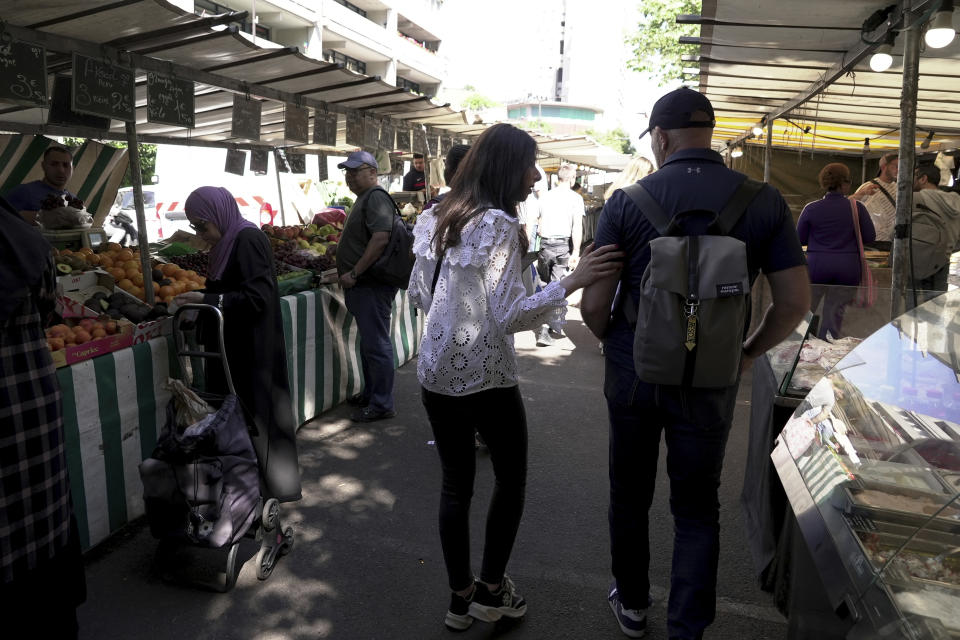 Shannon Seban, a legislative election candidate for the camp of President Emmanuel Macron, campaigns, in the Paris suburb of Ivry-sur-Seine, Tuesday June 25, 2024. Antisemitism has surged as a hot-button issue in France's high-stakes legislative election campaign. On the outskirts of Paris, a candidate who is Jewish is feeling the heat of hatred. Campaigning for the camp of President Emmanuel Macron, Shannon Seban is accompanied by bodyguards as she canvasses for votes, because her party is concerned for her safety. (AP Photo/John Leicester)