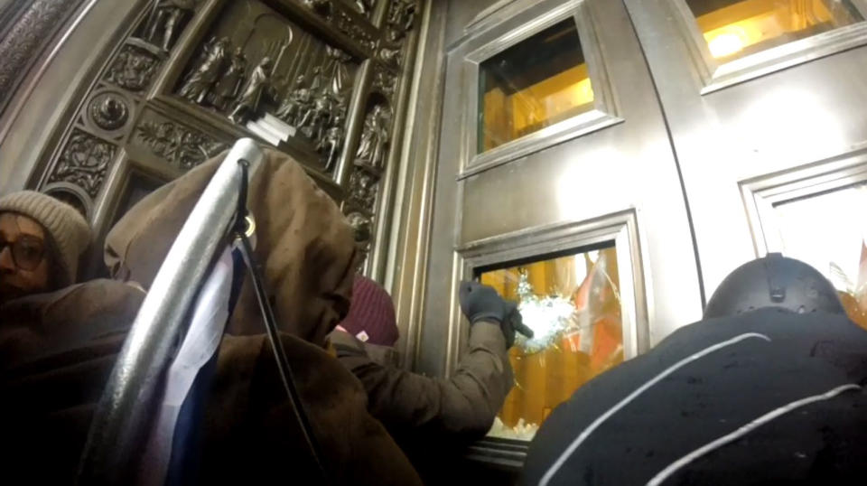 A rioter tries to smash out the window to the door leading into the Capitol rotunda. (U.S. District Court for the District of Columbia)