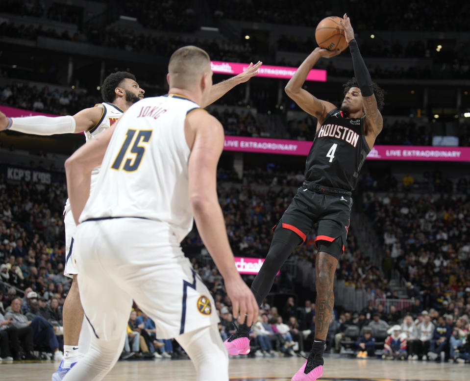 Houston Rockets guard Jalen Green shoots as Denver Nuggets guard Jamal Murray, back, and center Nikola Jokic defend during the second half of an NBA basketball game Friday, Dec. 8, 2023, in Denver. (AP Photo/David Zalubowski)