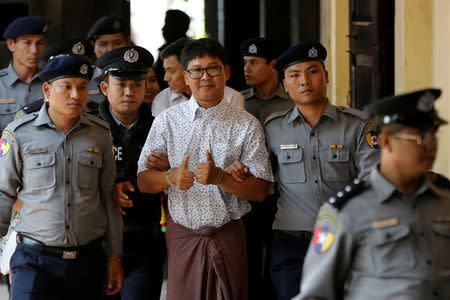 FILE PHOTO: Detained Reuters journalist Wa Lone is escorted by police before a court hearing in Yangon, Myanmar April 20, 2018. REUTERS/Ann Wang