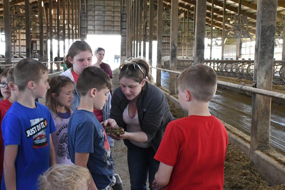 WB_Farm_Field_Trip_14.jpg - Mary Fannin from Farm Credit shows students silage that is fed to the dairy cows.