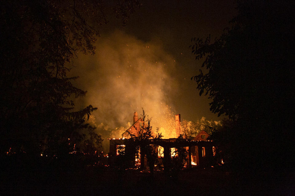 Las llamas se elevan desde una casa mientras un incendio forestal arrasa la región en Las Golondrinas en la provincia de Chubut, Argentina, el miércoles 10 de marzo de 2021. (AP Foto/Matías Garay )