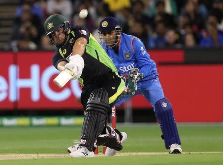 Australia's Aaron Finch (L) hits a six while batting with India's Mahendra Singh Dhoni watching during their T20 cricket match at the Melbourne Cricket Ground, Australia January 29, 2016. REUTERS/Hamish Blair