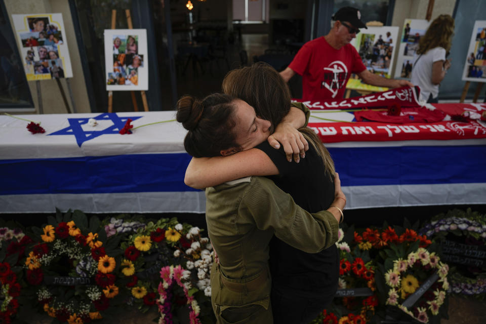 FILE - Mourners embrace during the funeral of Meni and Ayelet Godard, in Kibbutz Palmachim, Israel Sunday, Oct. 29, 2023. Israel and Hamas have been at war for 100 days. The war already is the longest and deadliest between Israel and the Palestinians since Israel’s establishment in 1948, and the fighting shows no signs of ending. (AP Photo/Ariel Schalit, File)