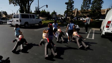 Children drag pinatas depicting Donald Trump during a rally to encourage people to vote in Norwalk, California. REUTERS/Mario Anzuoni