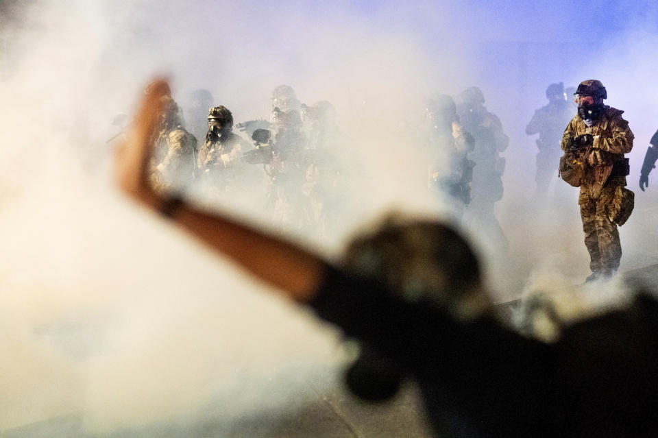 FILE - In this July 24, 2020, file photo, federal officers use chemical irritants and projectiles to disperse Black Lives Matter protesters at the Mark O. Hatfield United States Courthouse in Portland, Ore. An Associated Press analysis of more than 200 arrests shows that even those accused of breaking the law during the nightly rallies don’t neatly fit into President Donald Trump’s depiction of protesters as “anarchists and agitators.” (AP Photo/Noah Berger, File)