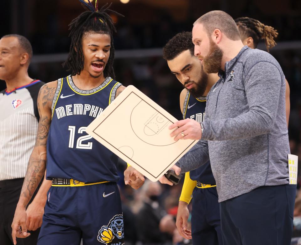 Memphis Grizzlies guard Ja Morant (12) and Tyus Jones (21) speak with Head Coach Taylor Jenkins on the sidelines during their 118-105 win over the San Antonio Spurs at FedExForum on Monday, Feb. 28, 2022. 