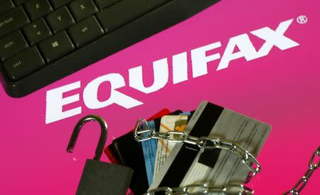 Credit cards, a chain and an open padlock is seen in front of displayed Equifax logo in this illustration taken September 8, 2017. REUTERS/Dado Ruvic/Illutration