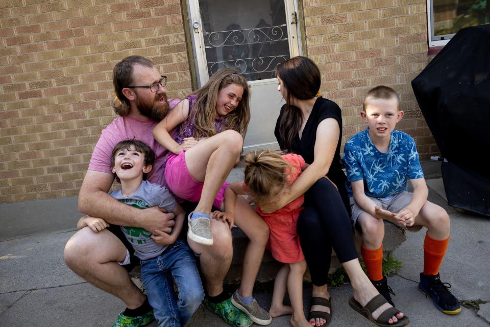 Josh and Aubrey Mitchell and their children, from left, Elliot, 6; Zoey, 7; Pyper, 4; and Owen, 9, hang out outside their home after dinner in Midvale on Tuesday, May 30, 2023. | Spenser Heaps, Deseret News