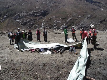 ATTENTION EDITORS - VISUAL COVERAGE OF SCENES OF INJURY OR DEATH Recovered bodies are lined up after a massive avalanche triggered by last week's earthquake overwhelmed Langtang village, Nepal, in this May 2, 2015 police handout photo. Rescue workers are struggling to recover the bodies of nearly 300 people, including about 110 foreigners, believed to be buried under up to six metres (20 feet) of ice, snow and rock from the landslide that destroyed Langtang village. Picture taken May 2, 2015. REUTERS/Handout via Reuters ATTENTION EDITORS - NO SALES. NO ARCHIVES. FOR EDITORIAL USE ONLY. NOT FOR SALE FOR MARKETING OR ADVERTISING CAMPAIGNS. THIS PICTURE WAS PROVIDED BY A THIRD PARTY. REUTERS IS UNABLE TO INDEPENDENTLY VERIFY THE AUTHENTICITY, CONTENT, LOCATION OR DATE OF THIS IMAGE. THIS PICTURE IS DISTRIBUTED EXACTLY AS RECEIVED BY REUTERS, AS A SERVICE TO CLIENTS. TEMPLATE OUT