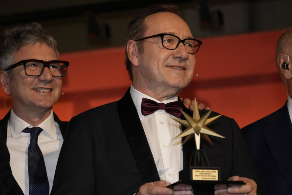 Actor Kevin Spacey, right, is flanked by National Museum of Cinema's director Domenico De Gaetano, as he receives an award at the National Museum of Cinema in Turin, Italy, Monday, Jan. 16, 2023. Kevin Spacey was in the northern Italian city of Turin on Monday to receive the lifetime achievement award, teach a master class and introduce a screening of the 1999 film "American Beauty." (AP Photo/Luca Bruno)