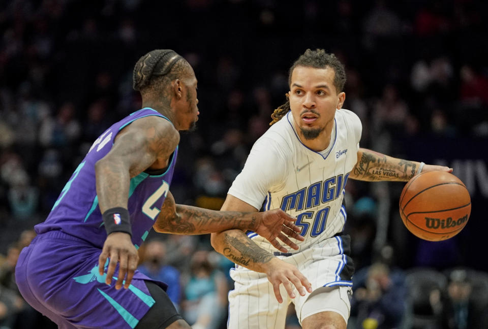 Orlando Magic guard Cole Anthony (50) drives around Charlotte Hornets guard Terry Rozier (3) during the first half of an NBA basketball game on Friday, Jan. 14, 2022, in Charlotte, N.C. (AP Photo/Rusty Jones)