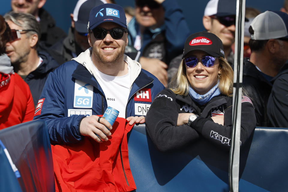 United States' Mikaela Shiffrin, right, and Norway's Aleksander Aamodt Kilde stand in the finish area and follow an alpine ski women's World Cup downhill, in Saalbach, Austria, Saturday, March 23, 2024. (AP Photo/Alessandro Trovati)