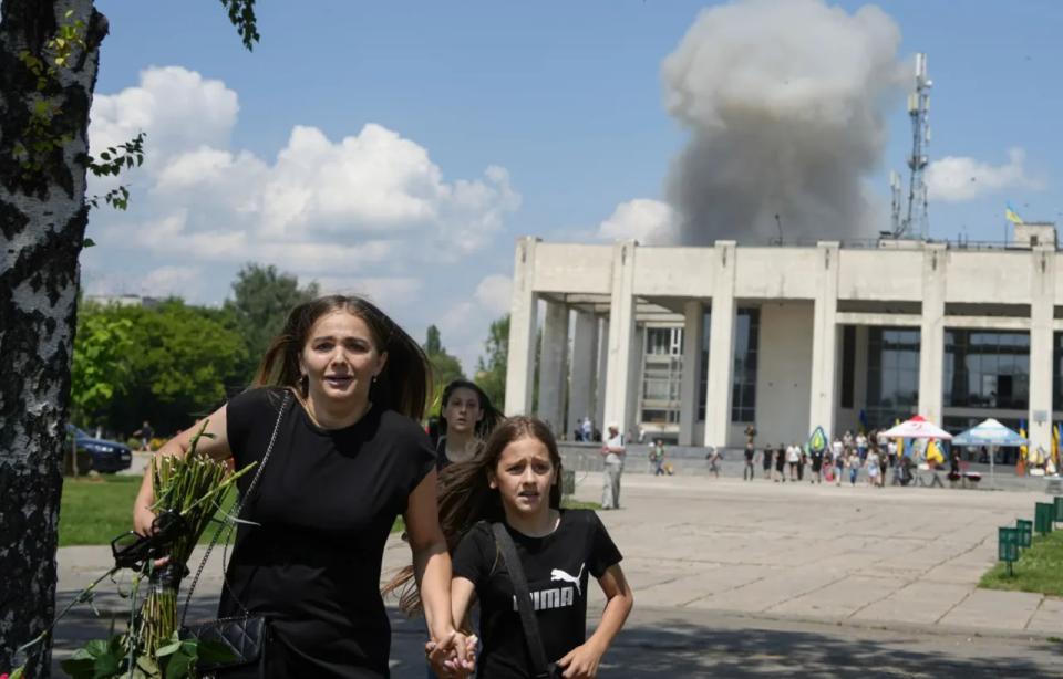 A family runs away from an explosion after a Russian missile strike on a residential area in Pervomaisk, Kharkiv Oblast, Ukraine, July 4. <span class="copyright">Oleksandr Magula—AP</span>