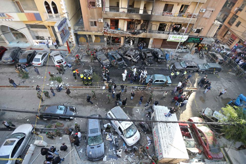 Lebanese army soldiers and forensic inspectors gather to examine the site of an explosion in the Haret Hreik area in the southern suburbs of the Lebanese capital Beirut