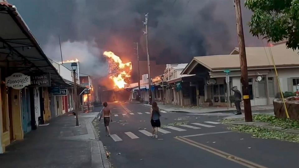 PHOTO: People watch as smoke and flames fill the air from raging wildfires on Front Street in downtown Lahaina, Maui, Aug. 8, 2023. (Alan Dickar/AP)