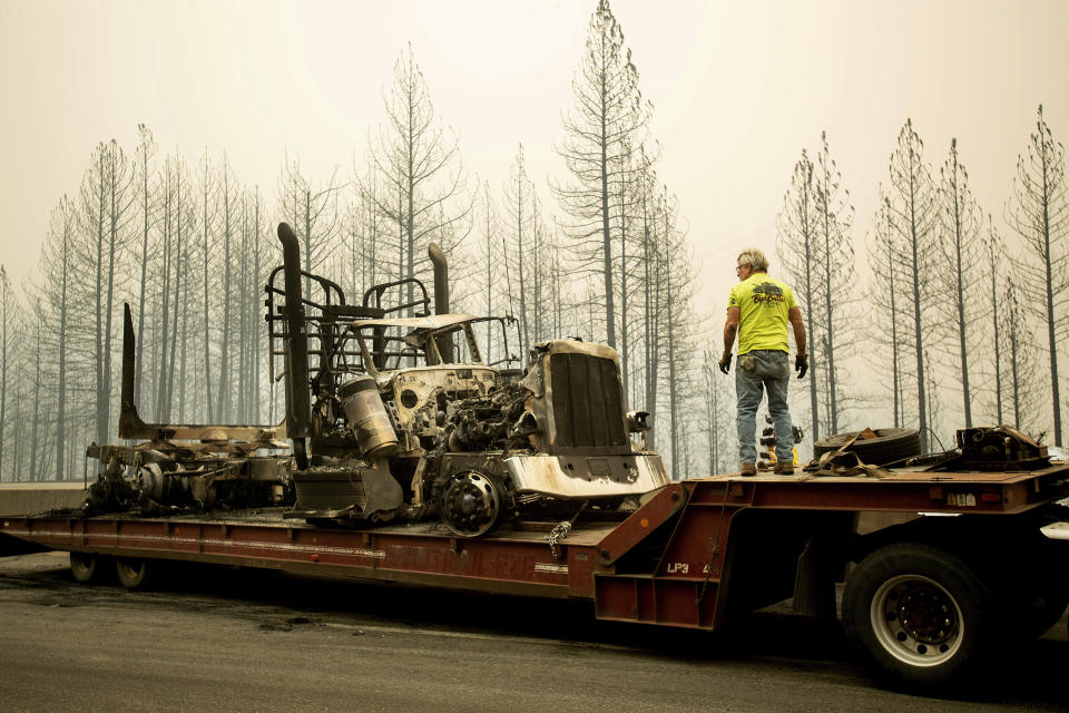 Bruce Palmer prepares to tow a truck scorched by the Delta Fire on Interstate 5 in the Shasta-Trinity National Forest, Calif., near Shasta Lake on Thursday, Sept. 6, 2018. The highway remains closed to traffic in both directions as crews battle the blaze. (AP Photo/Noah Berger)