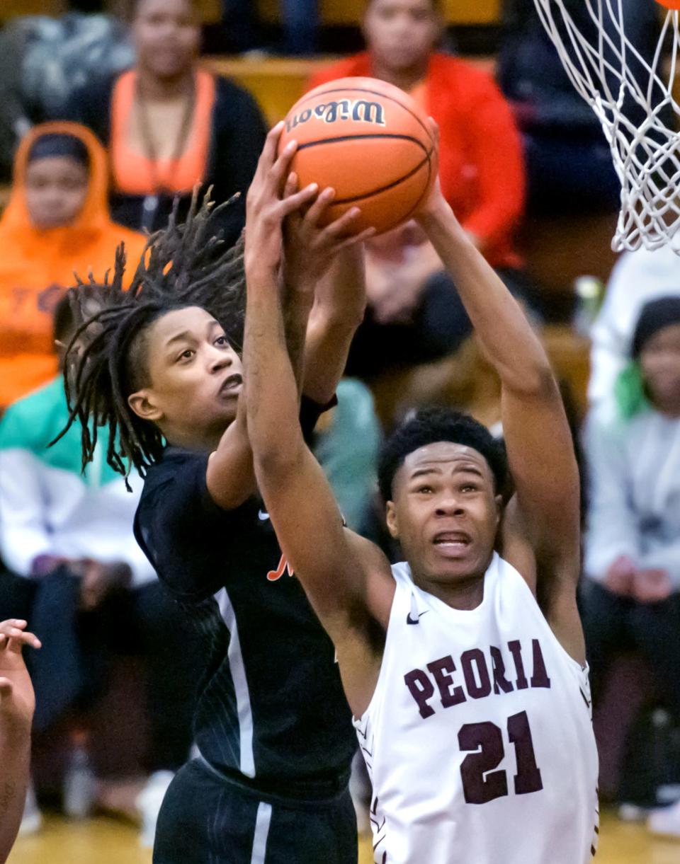 Peoria High's LeShawn Stowers (21) and Manual's Dietrich Richardson battle for a rebound in the second half Saturday, Feb. 14, 2023 at Peoria High School. The Rams rallied to defeat the Lions 66-61.