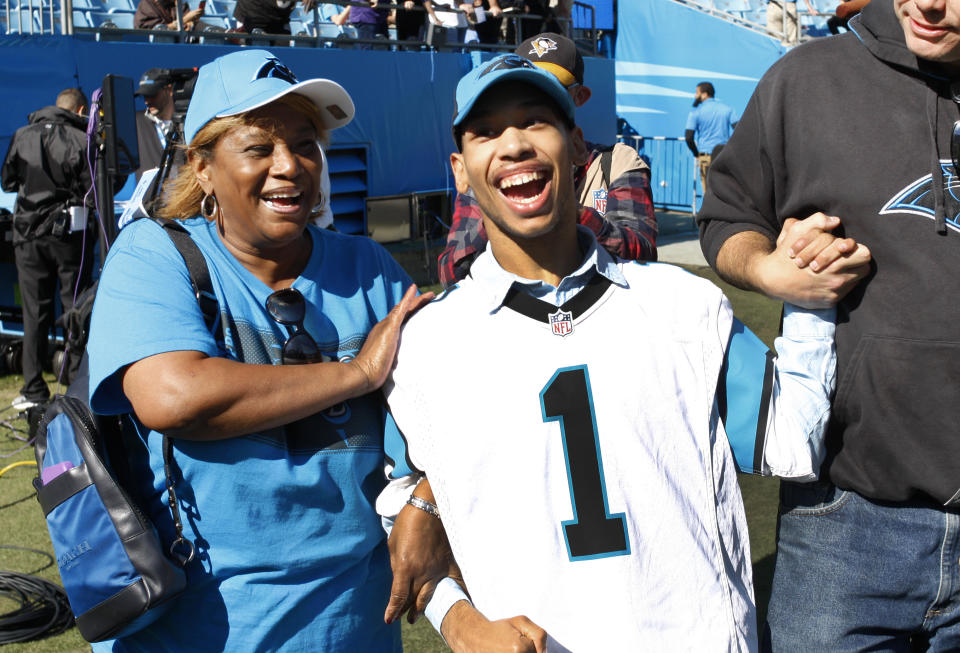 Chancellor Lee Adams, right, son for former Carolina Panthers' Rae Carruth, walks on the field with his grandmother, Saundra Adams, left, before an NFL football game between the Carolina Panthers and the Baltimore Ravens in Charlotte, N.C., Sunday, Oct. 28, 2018. (AP Photo/Nell Redmond)