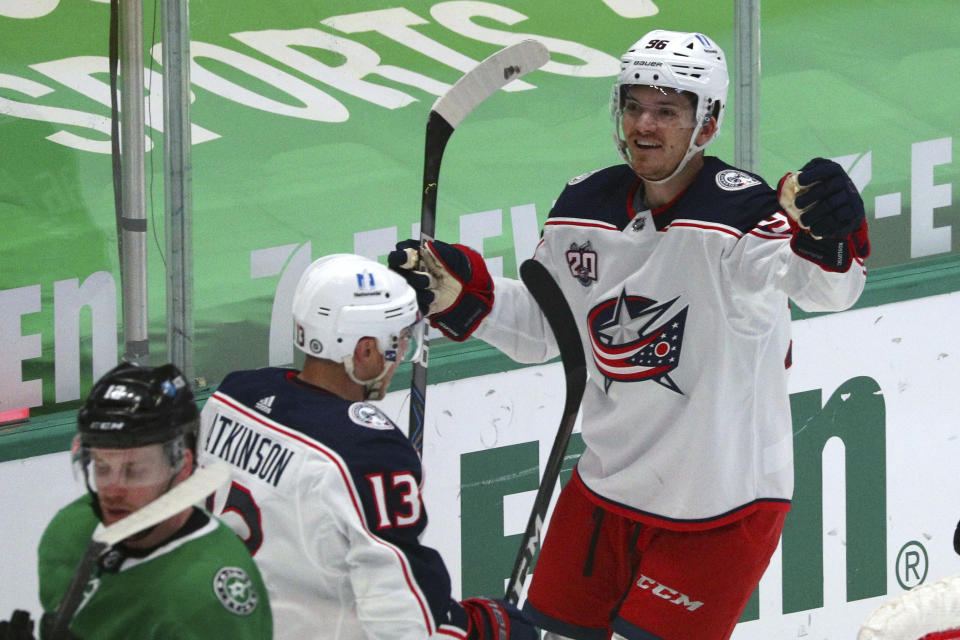 Columbus Blue Jackets right wing Cam Atkinson (13) celebrates a goal by center Jack Roslovic (96) against the Dallas Stars during the first period during an NHL hockey game on Thursday, April 15, 2021, in Dallas. (AP Photo/Richard W. Rodriguez)