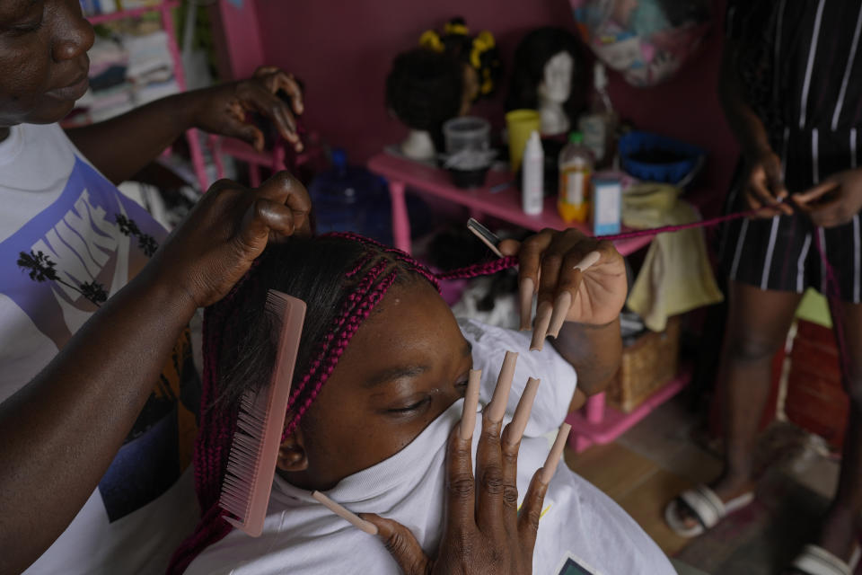 Felasha Duncan gets pink hair extensions at an open-air salon in Ann's Grove, Guyana, Saturday, April 15, 2023. “I expected a better life since the drilling began,” said Duncan, a 36-year-old mother of three, referring to oil the nation's oil discovery. (AP Photo/Matias Delacroix)