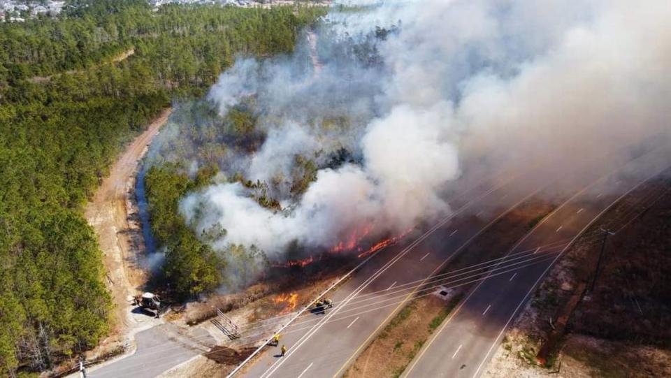 Prescribed fire burning near International Drive, with smoke and flames moving away from Lewis Ocean Bay Heritage Preserve.