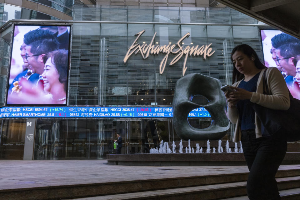 A pedestrian passes by the Hong Kong Stock Exchange electronic screen in Hong Kong, Thursday, March 30, 2023. Asian shares were mixed Thursday following a rally on Wall Street as worries over banks following the collapses of several lenders in recent weeks eased further. (AP Photo/Louise Delmotte)