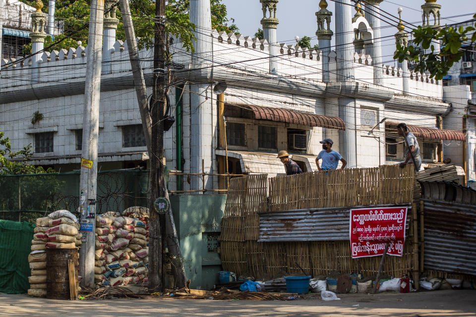 Residents watch as soldiers and police remove improvised barricades installed by anti-coup protesters and residents to secure a neighborhood from security forces in Yangon, Myanmar Thursday, March 18, 2021. (AP Photo)