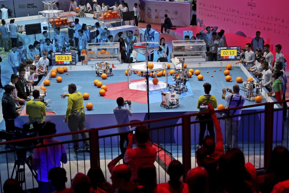 In this Friday, Oct. 25, 2019 photo, a team from Cameroon, on the right, compete with Luxembourg during the First Global Challenge, a robotics and artificial intelligence competition in Dubai, United Arab Emirates. Seeking to bolster its image as a forward-looking metropolis, Dubai hosted the largest-ever international robotics contest this week, challenging young people from 190 countries to find solutions to global ocean pollution. (AP Photo/Kamran Jebreili)