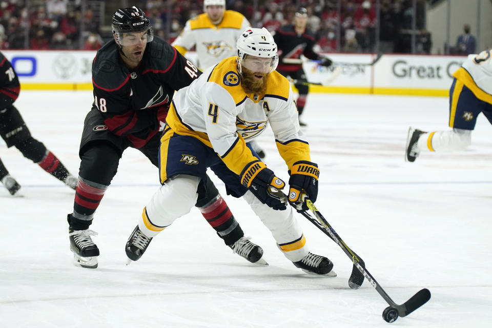 Carolina Hurricanes left wing Jordan Martinook (48) pursues as Nashville Predators defenseman Ryan Ellis (4) controls the puck during the second period in Game 1 of an NHL hockey Stanley Cup first-round playoff series in Raleigh, N.C., Monday, May 17, 2021. (AP Photo/Gerry Broome)