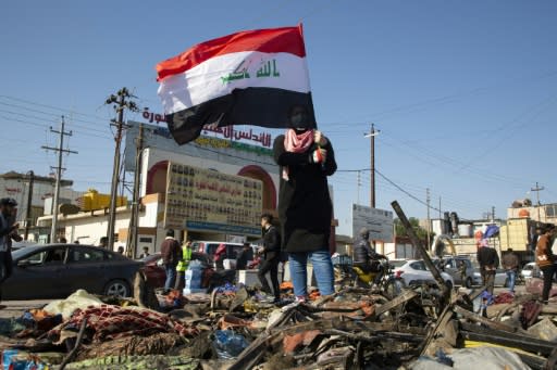 An Iraqi demonstrator stands on the debris of a protest camp that was dismantled by riot police in the southern oil hub of Basra