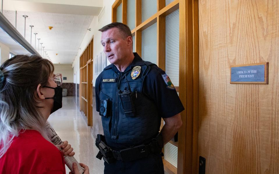 Bryn Taylor, Graduate Assistants United co-president, speaks to Maj. B. C. Knowles during the protest on Ben Sasse's first day as the University of Florida president.