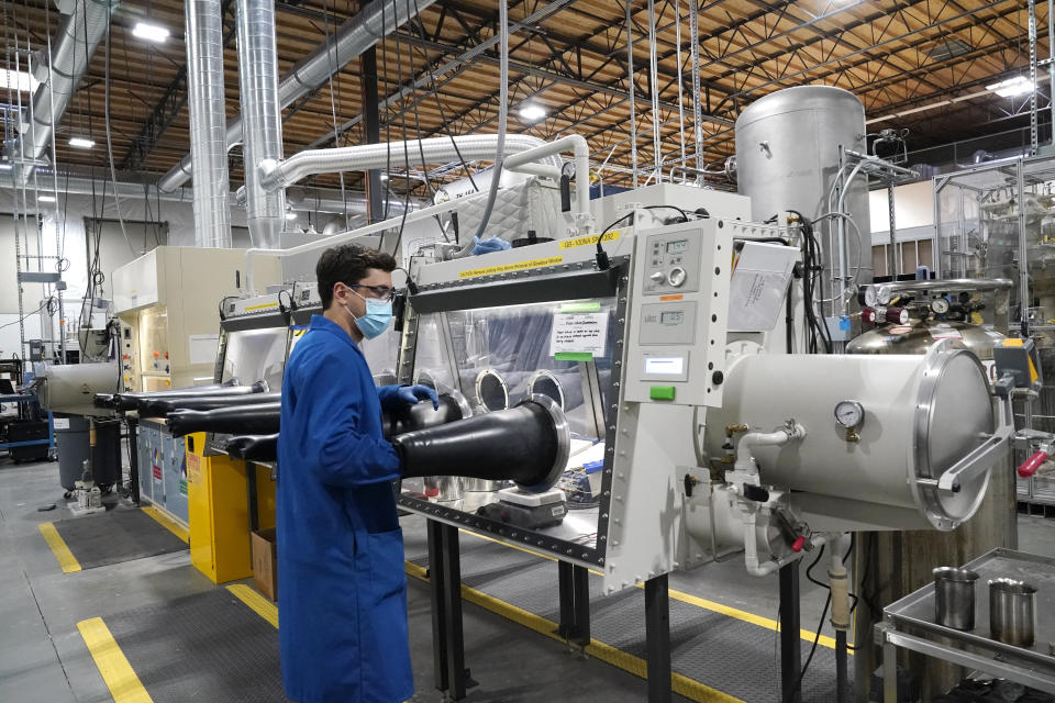 FILE - Test engineer Jacob Wilcox pulls his arm out of a glove box used for processing sodium at TerraPower, a company developing and building small nuclear reactors, Jan. 13, 2022, in Everett, Wash. A major economic bill headed to the president has “game-changing” incentives for the nuclear energy industry, experts say, and those tax credits are even more substantial if a facility is sited in a community where a coal plant is closing. Bill Gates' company, TerraPower, plans to build an advanced, nontraditional nuclear reactor and employ workers from a local coal-fired power plant scheduled to close soon. (AP Photo/Elaine Thompson, File)