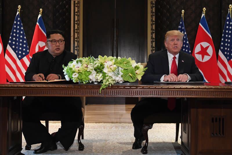 美國總統川普12日與北韓領袖金正恩舉行歷史性峰會，兩人共同在媒體面前簽署文件。（法新社）