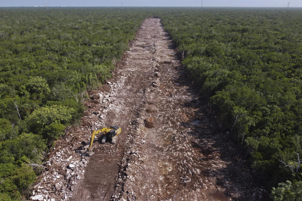 FILE - A bulldozer clears an area of forest that will be the line of the Mayan Train in Puerto Morelos, Quintana Roo state, Mexico, Aug. 2, 2022. Mexican President Andrés Manuel López Obrador loves big projects and hates to leave them unfinished, but that is likely what he will do when he leaves office in September 2024, including this tourist train line in the Yucatan peninsula which will have to be jacked up on stilts for 50 miles to run over some of the most fragile and environmentally sensitive geography in the world. (AP Photo/Eduardo Verdugo, File)